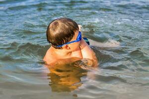 A happy child is swimming in the river on a very hot summer day. Swim in reservoirs. A happy family has fun and splashes in the water in the summer. photo