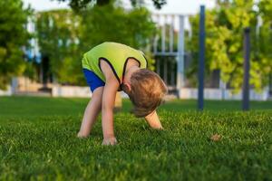 The child spends time in the park, he is very happy. Have fun and enjoy a summer day. Walking and recreation. photo