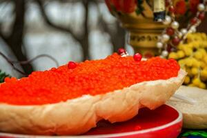 Red caviar is spread on bread with a thick layer. Maslenitsa street fair. photo