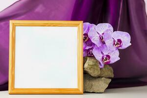 Mockup. Photo frame on the background of beautiful orchids. Stylish appearance of the product, layout, personality