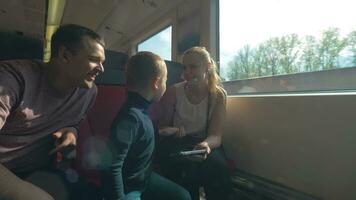pais e criança viajando de trem e usando celular video