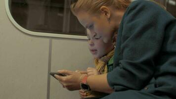 schot van moeder en zoon rijden in de metro trein gebruik makend van smartphone gedurende reis, Praag, Tsjechisch republiek video