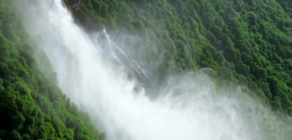 Mountain waterfall and spray waterfall background stream in nature rich in green trees photo