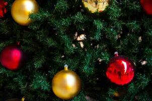 dorado y rojo pelotas decorado en Navidad árbol, decorado árbol, por lo general un hojas perennes conífera. foto