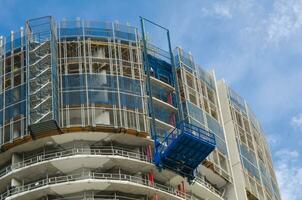 Construction Lift at scaffolding on building site is a temporary structure used to support workers and materials during the construction, maintenance or repair of buildings and other structures. photo