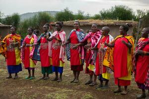 Masai in traditional colorful clothing showing Maasai jumping dance at local tribe village near famous Safari travel destination. Kenya. Editorial photo