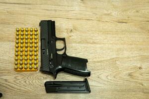 Handgun and bullets and mags lying on a wooden table photo