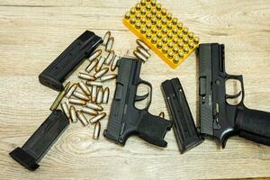 Handgun and bullets and mags lying on a wooden table photo