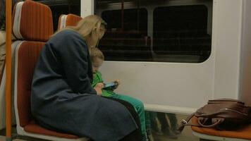 mãe e criança usando célula dentro comovente metrô trem video