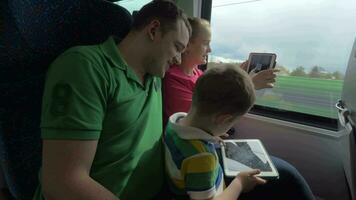 Family traveling by train and using digital tablets video