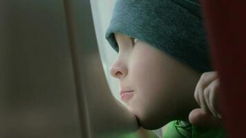 Close up view of small boy bored face in winter hat on his place in the rail train video