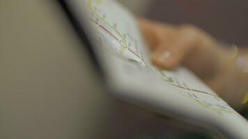 Close up view of hand with paper map of subway station and then reflection of map in train window video