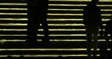 Silhouettes of people going up and down against lighting gold stairway Bangkok, Thailand video