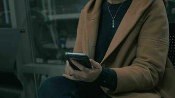 close up view of woman hands when she writing message on her smartphone in the subway wagon video