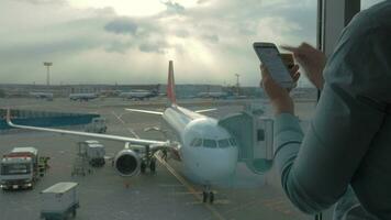 In airport view of woman making payment with bank card using smartphone and dongle for scanning bank card video