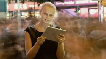 Timelapse of woman with pad in night crowded street video