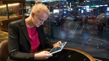 vrouw gebruik makend van stootkussen in cafe door venster met stad visie video