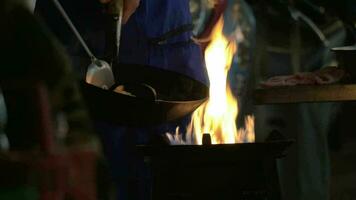hombre Cocinando fideos plato en wok en abierto fuego, Tailandia video