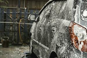 A grey car is being wash in a self-service car wash station. photo