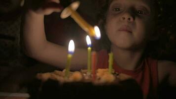 langzaam beweging visie van klein meisje verlichting de kaarsen Aan verjaardag taart in de donker video