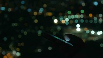 kvinna med mobil telefon mot natt suddig stadsbild video