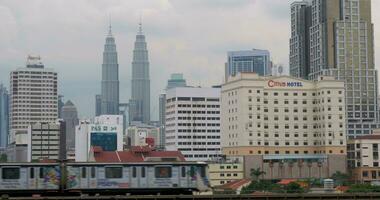 durch Schiene geht vorbei Zug im das Hintergrund gesehen Petronas Zwilling Türme, Hotel und Wolkenkratzer video