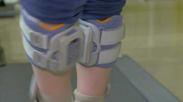 In Nea Kallikratia, Greece in clinic little boy slowly walks on the medical treadmill with an electronic device on legs video