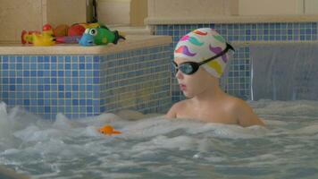 Aussicht von Junge spielen mit Spielzeug im das Kinder Schwimmen Schwimmbad video