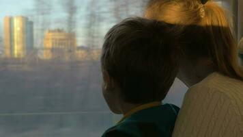 Mother and child looking out train window during the travel video