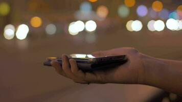 Young girl in evening street connects to the mobile phone portable charger video