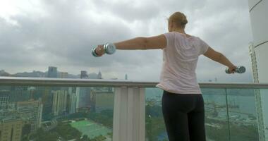 mujer haciendo hombro ejercicios en el balcón hong kong, China video