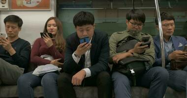 Subway passengers using cellphones Seoul, South Korea video