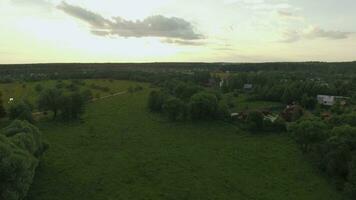 Visualizza di foresta, lago e nazione case contro blu cielo con sole e nuvole nel tramonto a estate, Russia video