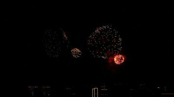 coloré brillant feux d'artifice dans le nuit ciel plus de le grattes ciels de une moderne ville. un événement fête concept video