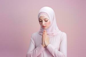 hijab mujer Orando con manos juntos aislado en rosado antecedentes ai generado foto