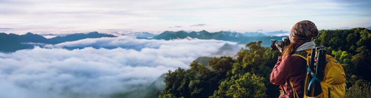 The young woman travels to take pictures of the sea mist on the mountain. Travel relax. Natural Touch countryside. at Chiangmai inThailand photo