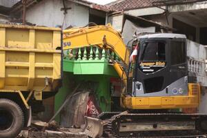 Magelang, Indonesia.09-17-2023.an excavator is dismantling and making a drainage hole photo