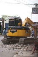 Magelang, Indonesia.09-17-2023.an excavator is dismantling and making a drainage hole photo