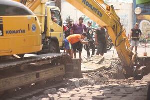 Magelang, Indonesia.09-17-2023.an excavator is dismantling and making a drainage hole photo