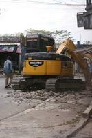 Magelang, Indonesia.09-17-2023.an excavator is dismantling and making a drainage hole photo