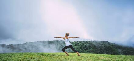 Asian women relax in the holiday. Play if yoga, natural forests, mountains and mist. photo