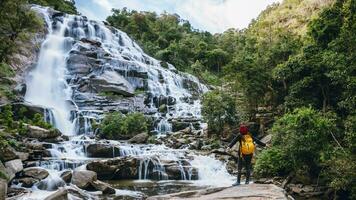 Women travel relax waterfall. In the winter. at the waterfall mae ya chiangmai in thailand. Natural background waterfall. travel nature. photo