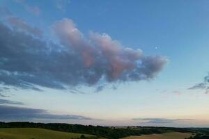 Most Beautiful High Angle view of Dramatical Sky and Clouds over British Countryside Landscape During Sunset photo