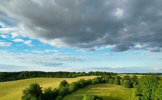 Most Beautiful High Angle view of Dramatical Sky and Clouds over British Countryside Landscape During Sunset photo