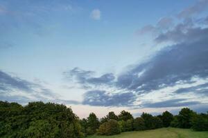 Most Beautiful High Angle view of Dramatical Sky and Clouds over British Countryside Landscape During Sunset photo