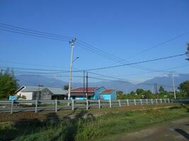 Palu City, Central Sulawesi, Indonesia - 26 August 2023 - View of the view with a mountainous background on South Tanggul road, South Palu District in the morning photo