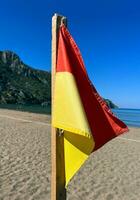 beach flag safety sand travel see side ocean flag red yellow flag wave sunny photo