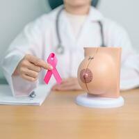 Pink October Breast Cancer Awareness month, doctor woman with pink Ribbon and Breast Anatomy model. National cancer survivors month, health diagnosis, Mother and World cancer day concept photo