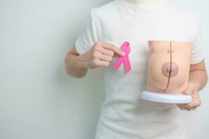 Pink October Breast Cancer Awareness month, woman with pink Ribbon and Breast Anatomy model. National cancer survivors month, health diagnosis, Mother and World cancer day concept photo