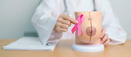 Pink October Breast Cancer Awareness month, doctor woman with pink Ribbon and Breast Anatomy model. National cancer survivors month, health diagnosis, Mother and World cancer day concept photo